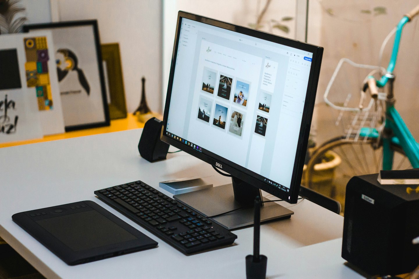 A graphic designer's desk with a Dell monitor and Wacom tablet.